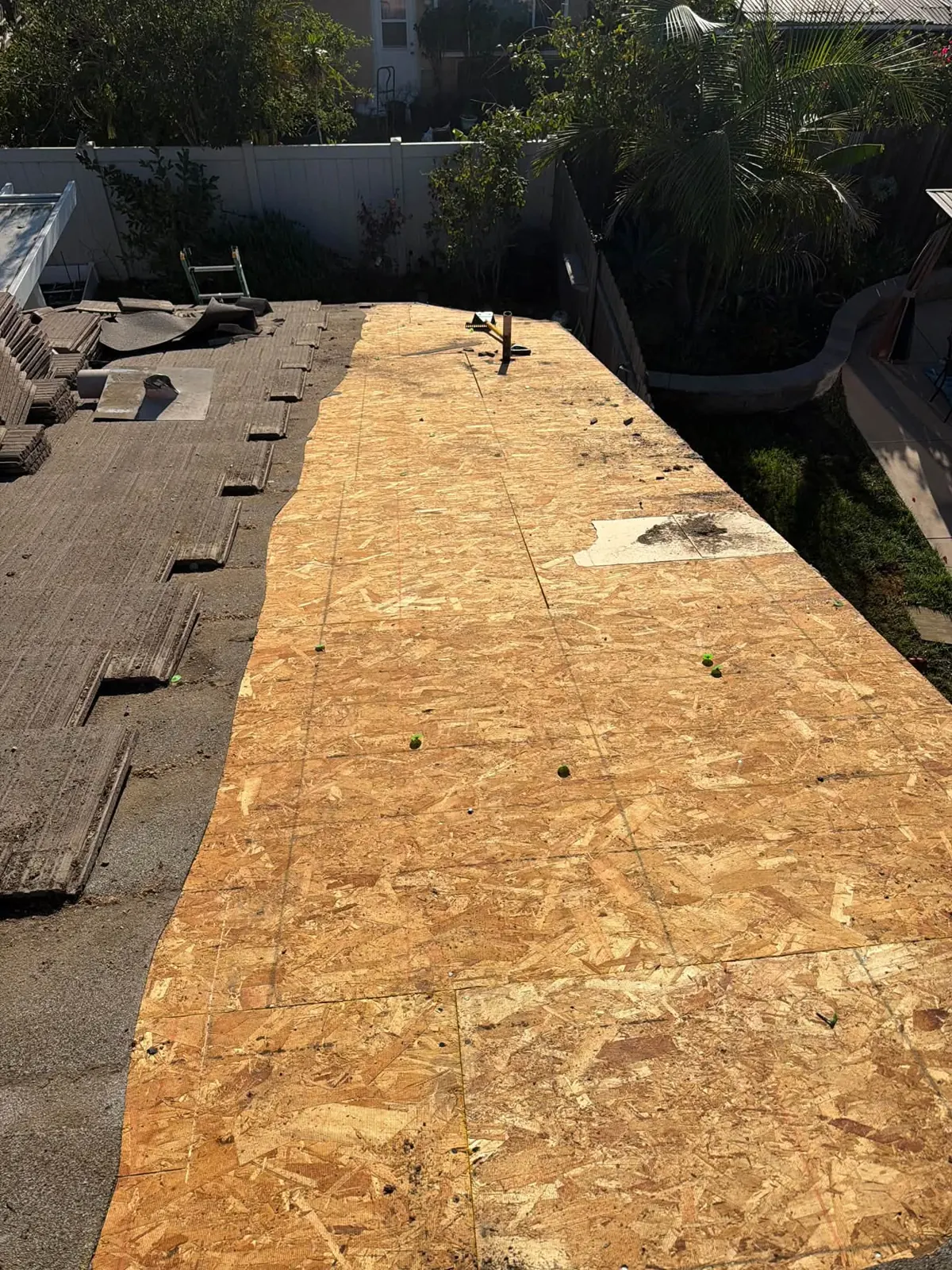 OSB decking going down next to an old tile roof