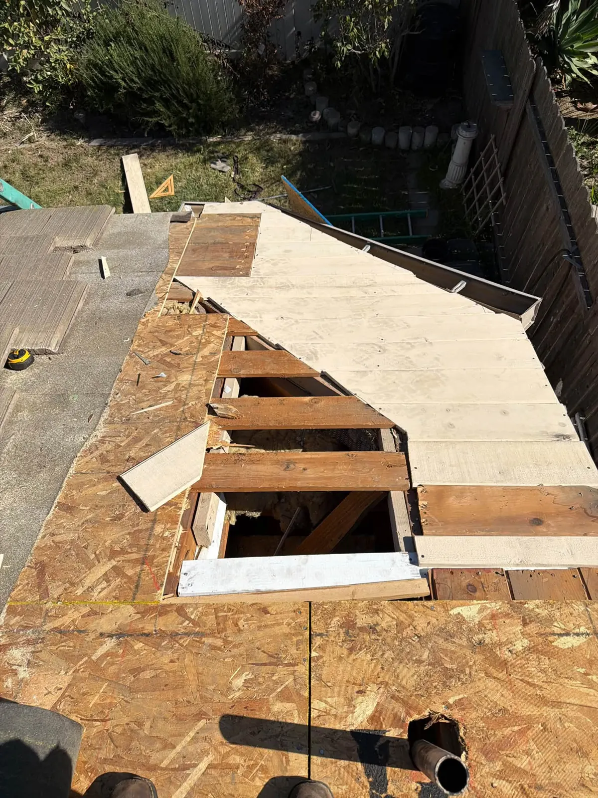 Opened roof deck showing rafters being repaired